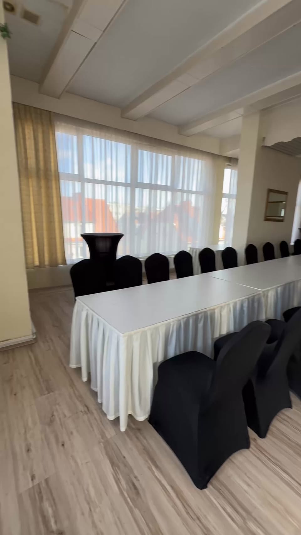 Sala bankietowa Kalinki z długimi stołami w białych obrusach i krzesłami w czarnych pokrowcach